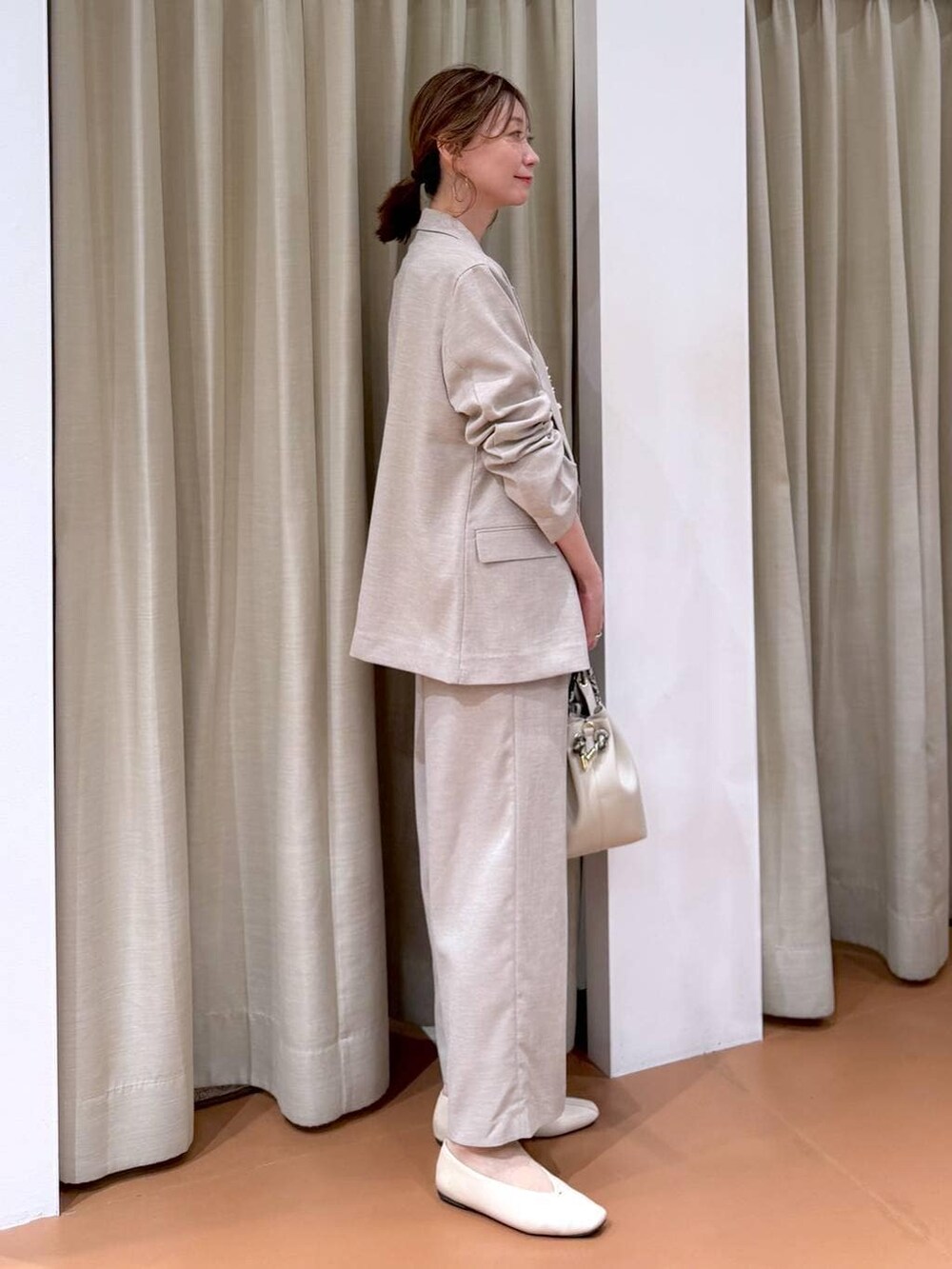 ホワイト系のパンプス、ホワイト系のハンドバッグ、ピンク系のシャツ/ブラウスを着用したレディースの春コーディネートの5枚目の写真