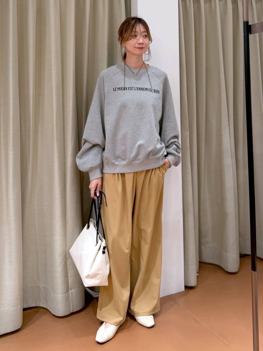 ホワイト系のパンプス、ホワイト系のトートバッグ、グレー系のスウェットを着用したレディースの春コーディネートの2枚目の写真
