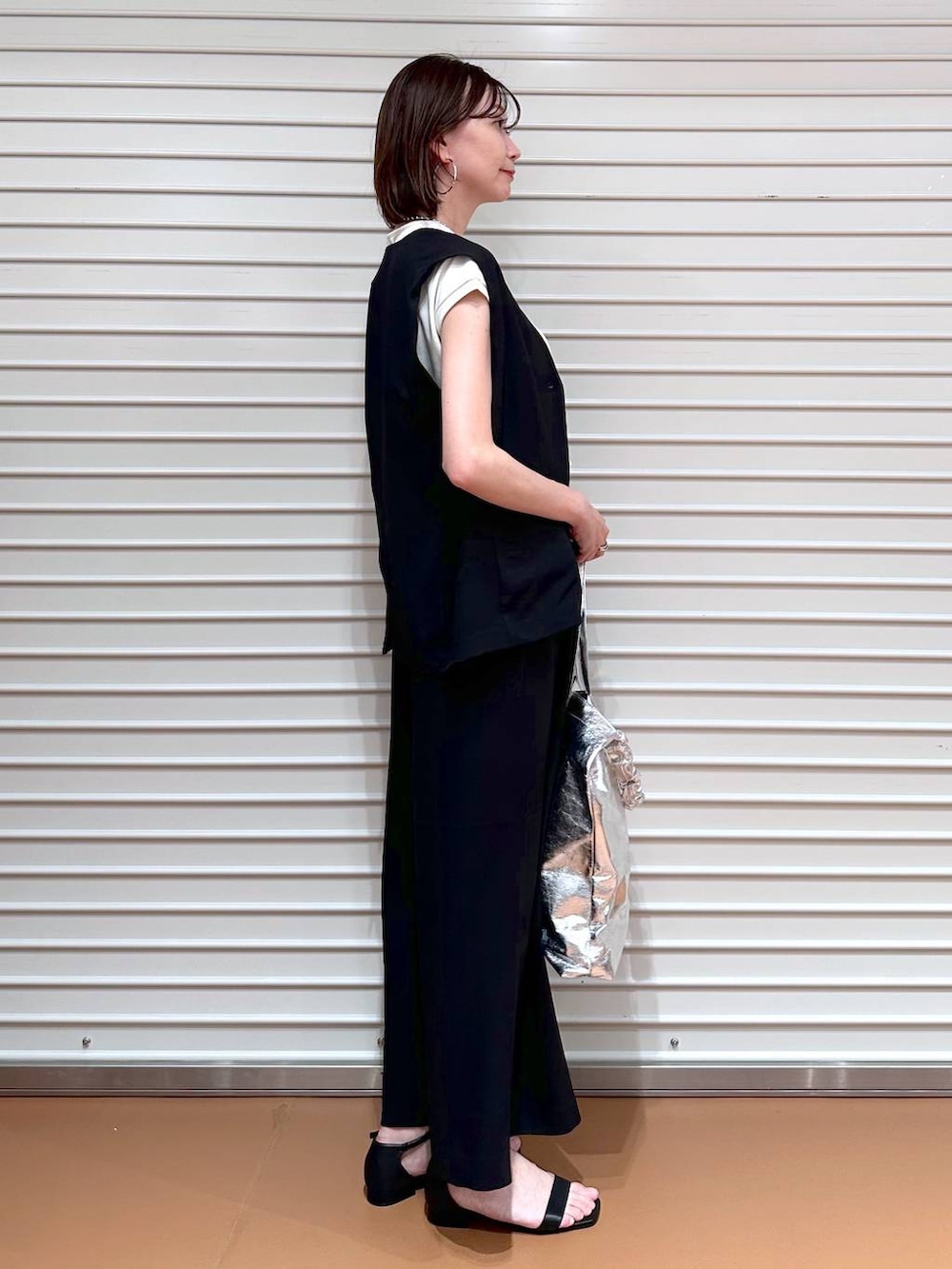 ブラック系のベスト、ホワイト系のTシャツ/カットソー、ブラック系のその他パンツを着用したレディースの夏コーディネートの3枚目の写真