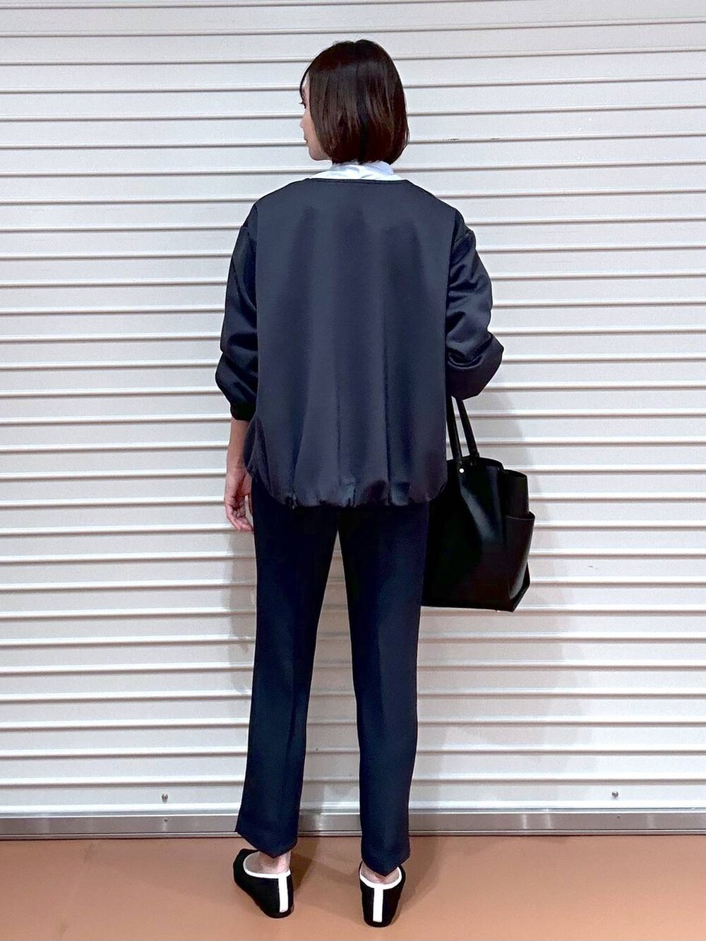 ブラック系のパンプス、ブラック系のトートバッグ、ブルー系のその他パンツを着用したレディースの春コーディネートの4枚目の写真