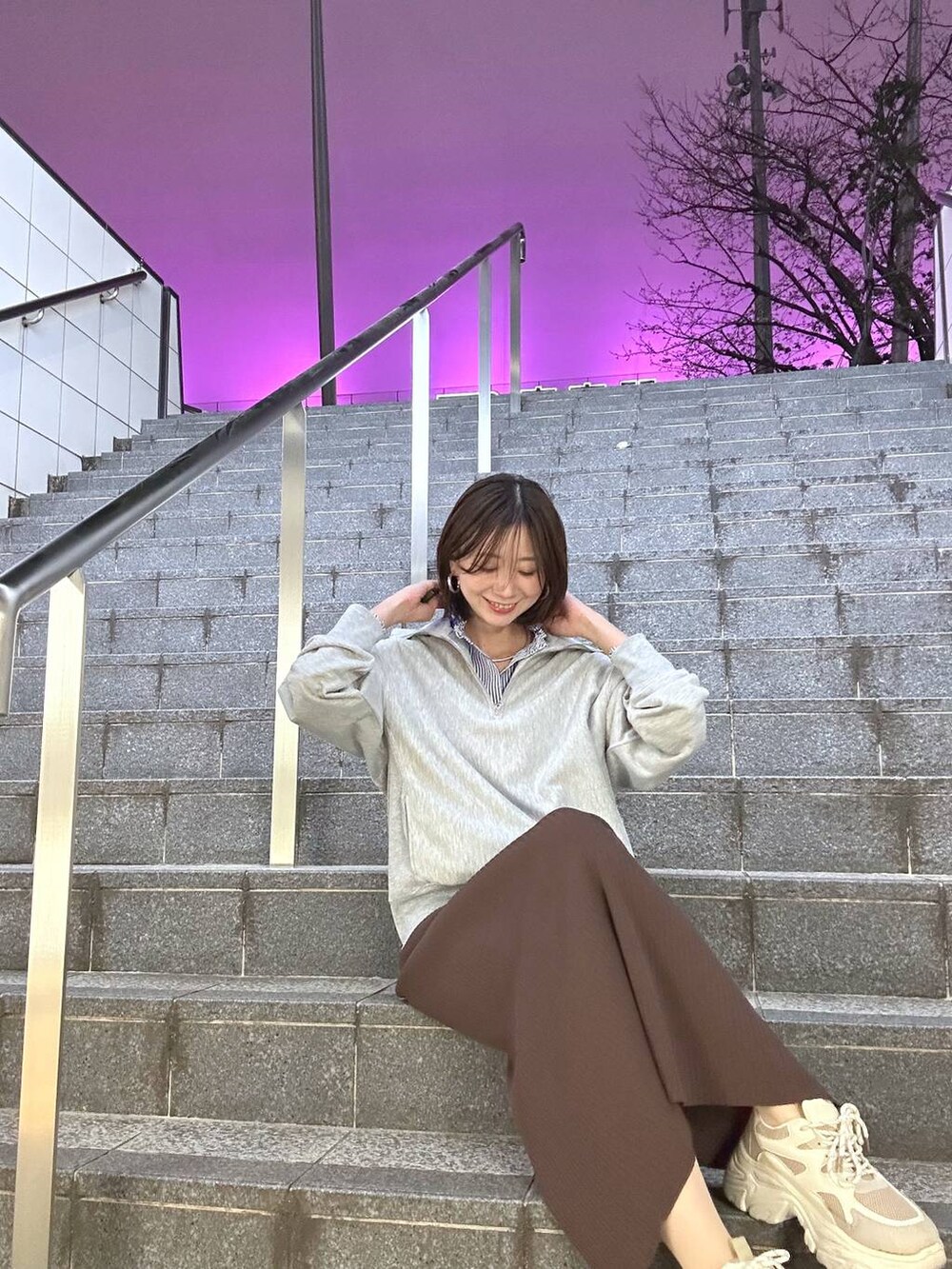 ブラウン系のスカート、グレー系のTシャツ/カットソー、ブルー系のシャツ/ブラウスを着用したレディースの春コーディネートの2枚目の写真