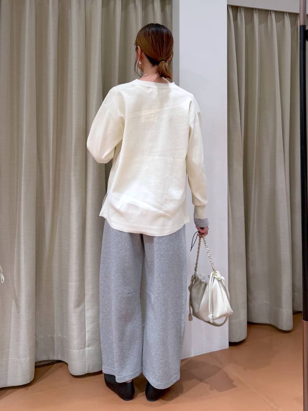 ホワイト系のカーディガン/ボレロ、ホワイト系のハンドバッグ、ブラック系のパンプスを着用したレディースの冬コーディネートの4枚目の写真