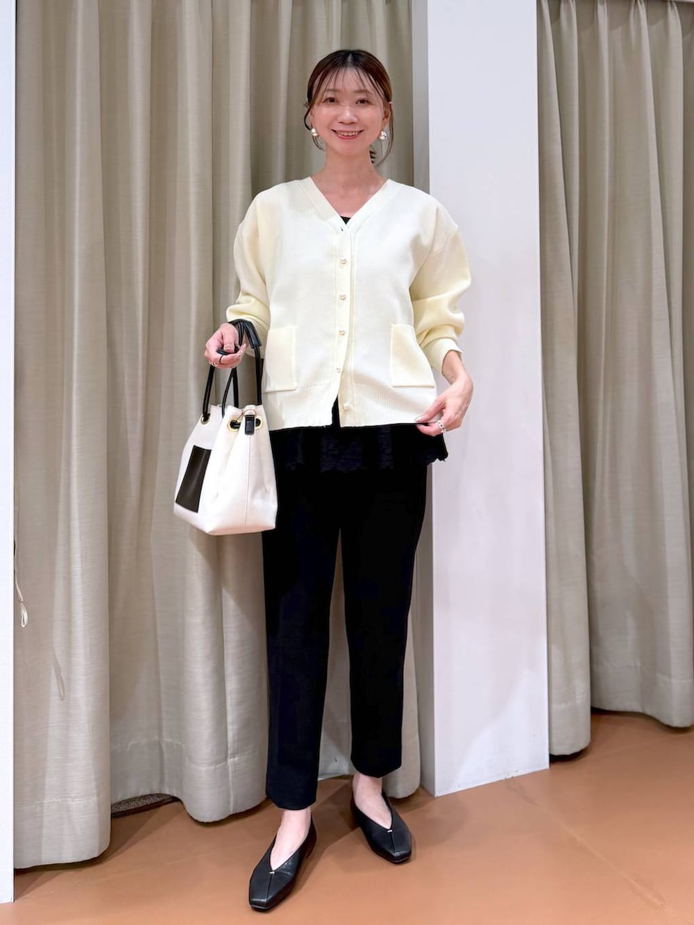 ブラック系のその他パンツ、ブラック系のパンプス、ホワイト系のトートバッグを着用したレディースの冬コーディネートの2枚目の写真