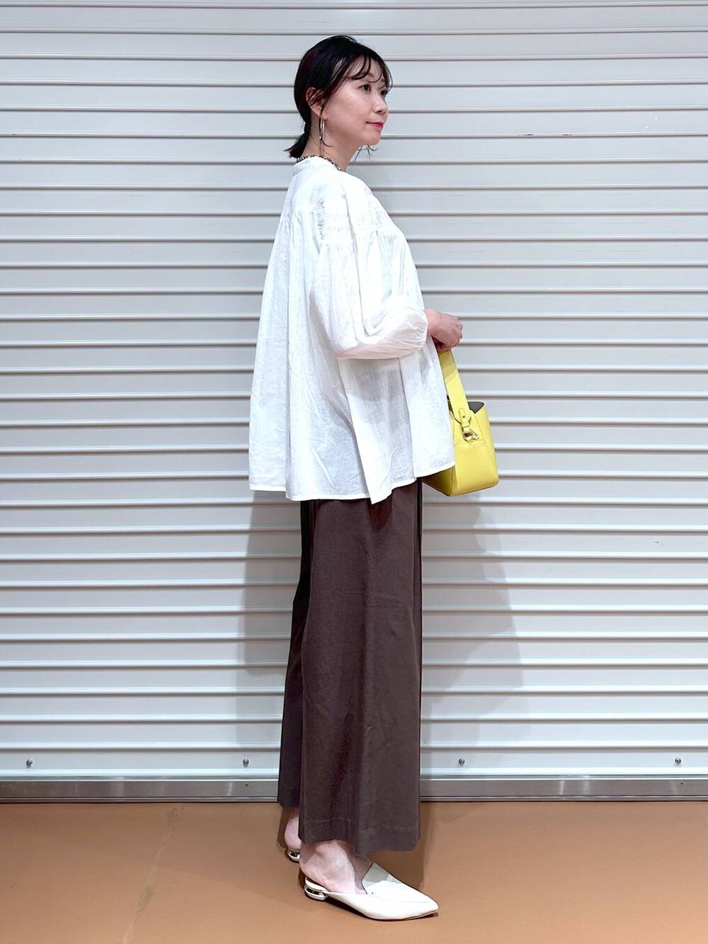 ブラウン系のその他パンツ、ブラウン系のその他パンツ、イエロー系のハンドバッグを着用したレディースの夏コーディネートの3枚目の写真