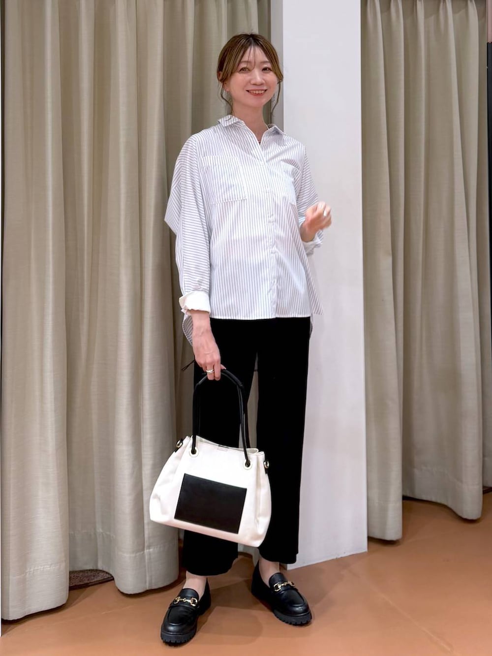 ブラック系のローファー、ホワイト系のトートバッグ、ホワイト系のシャツ/ブラウスを着用したレディースの春コーディネートの2枚目の写真