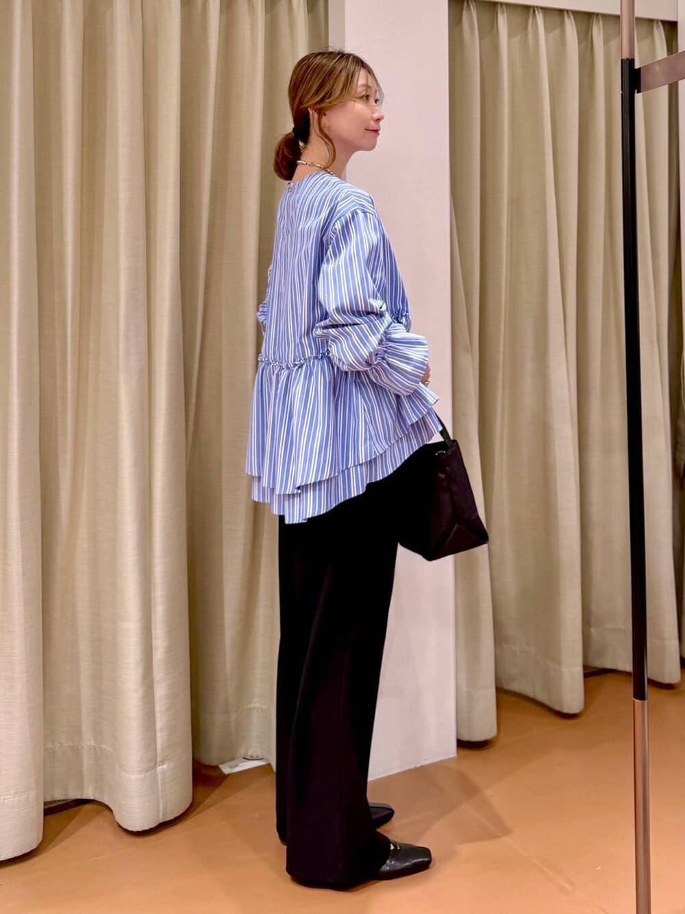 ブラック系のその他パンツ、ブラック系のパンプス、ブルー系のシャツ/ブラウスを着用したレディースの春コーディネートの5枚目の写真