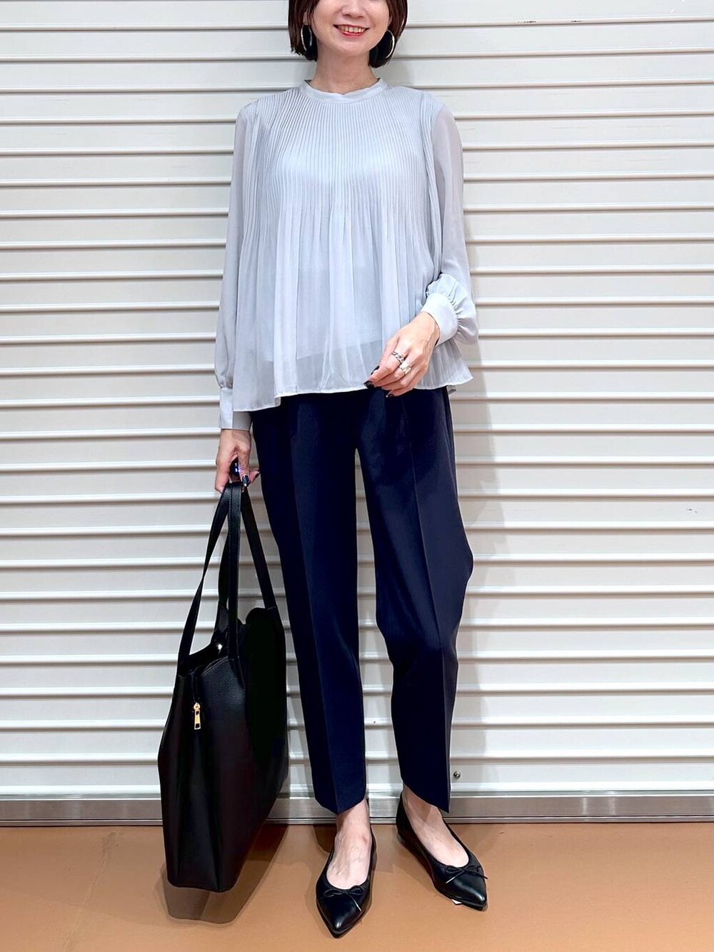 ブルー系のその他パンツ、ブラック系のトートバッグ、ブラック系のパンプスを着用したレディースの秋コーディネートの5枚目の写真