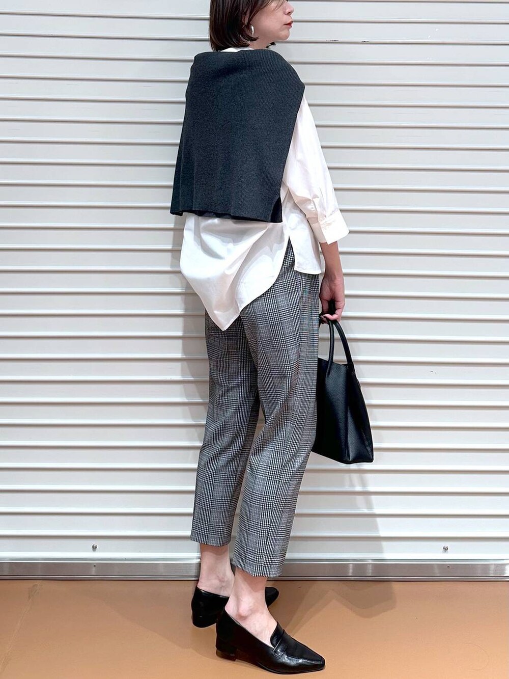 グレー系のニット/セーター、ブラック系のその他パンツ、ブラック系のハンドバッグを着用したレディースの秋コーディネートの6枚目の写真