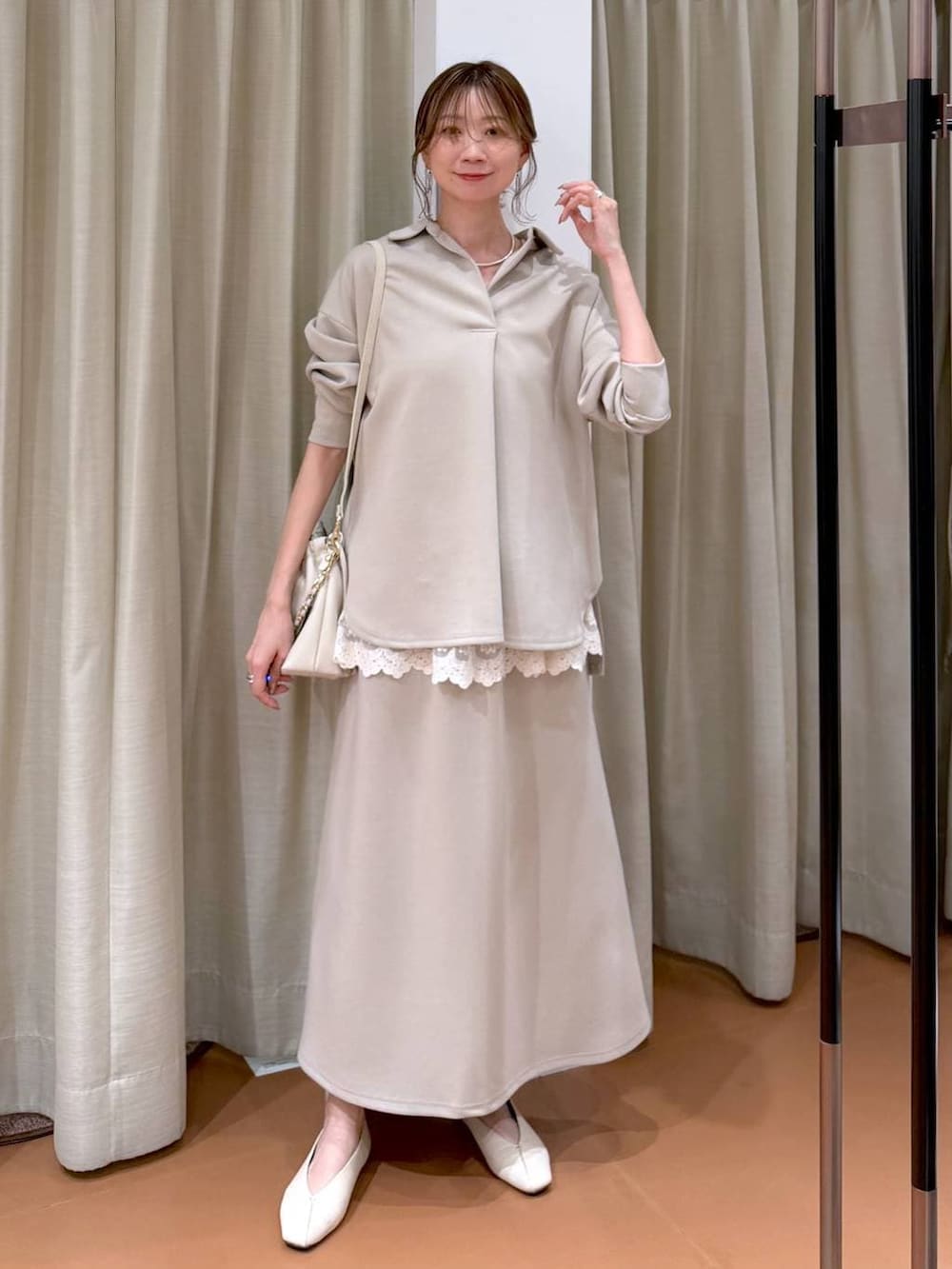 ホワイト系のハンドバッグ、ホワイト系のパンプス、ホワイト系のタンクトップを着用したレディースの冬コーディネートの2枚目の写真