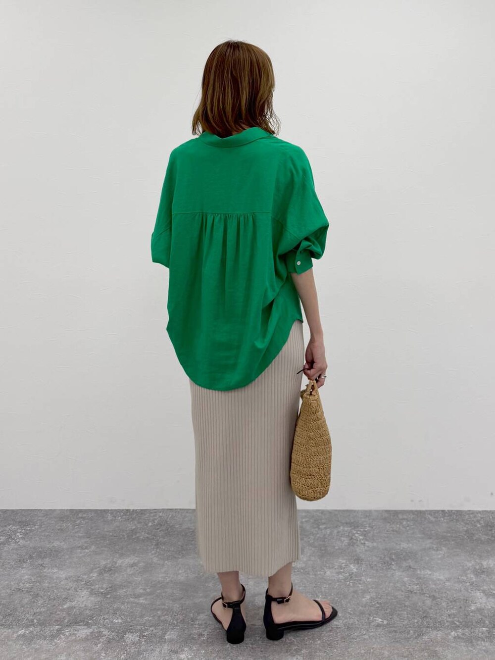 グリーン系のシャツ/ブラウス、ベージュ系のスカート、ゴールド系のネックレスを着用したレディースの春コーディネートの4枚目の写真