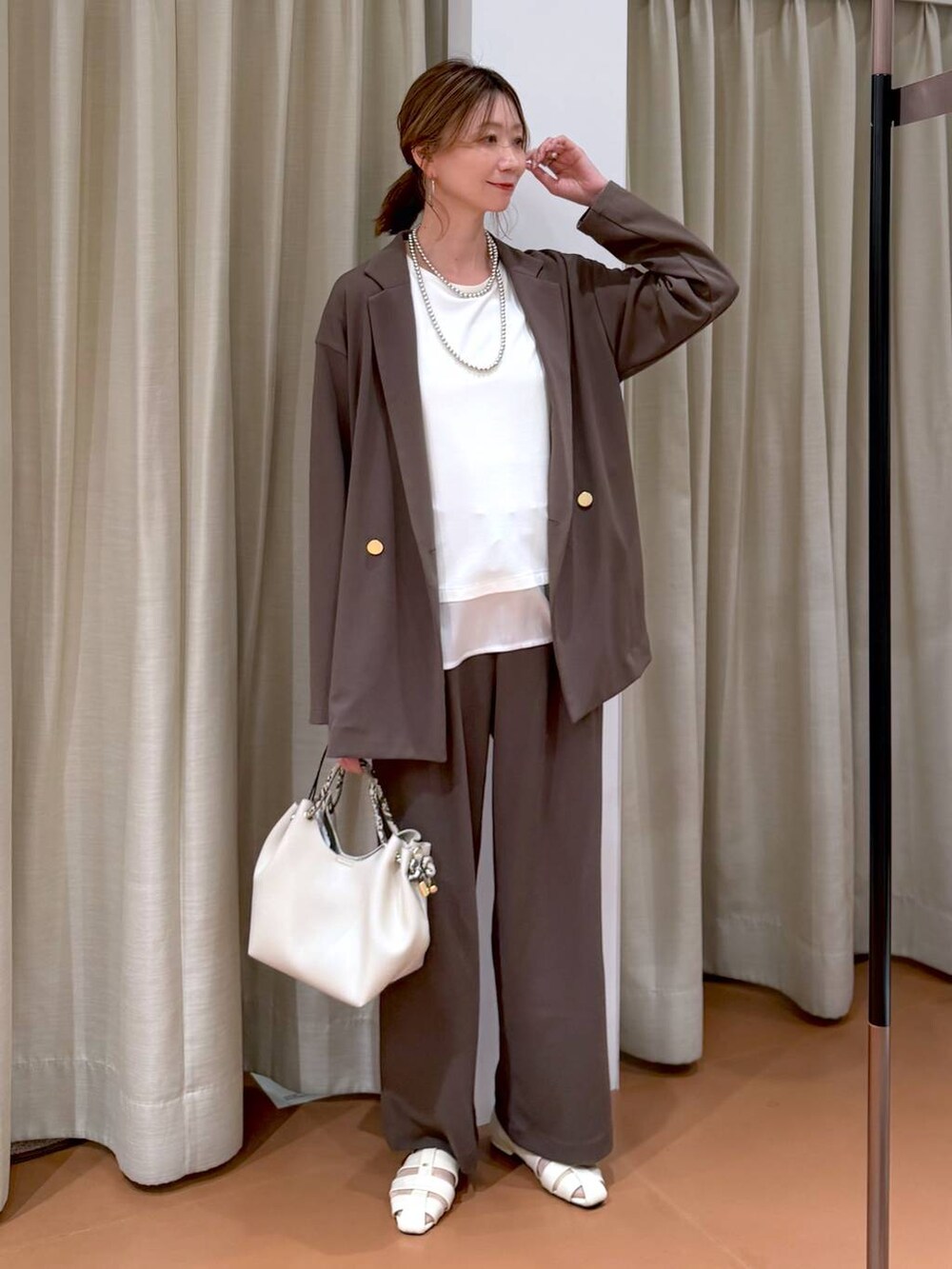 ブラウン系のその他パンツ、ホワイト系のパンプス、ホワイト系のTシャツ/カットソーを着用したレディースの春コーディネートの7枚目の写真