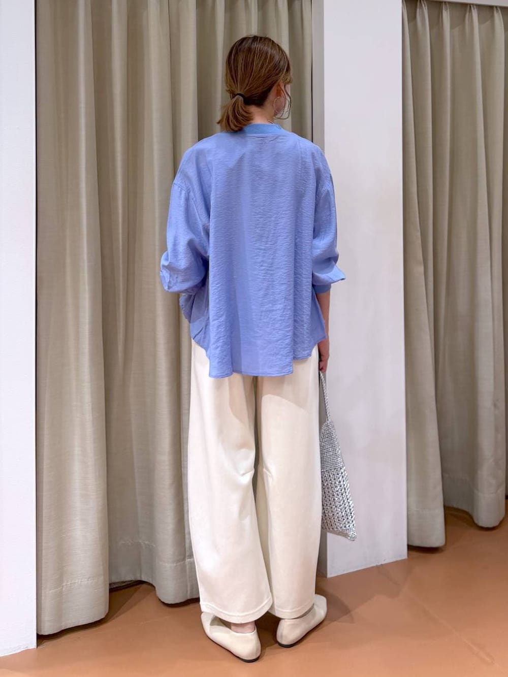 ホワイト系のTシャツ/カットソー、ホワイト系のパンプス、ブルー系のカーディガン/ボレロを着用したレディースの春コーディネートの4枚目の写真