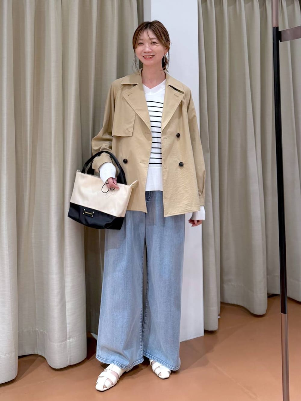 ブルー系のデニムパンツ、ホワイト系のパンプス、ホワイト系のTシャツ/カットソーを着用したレディースの春コーディネートの2枚目の写真