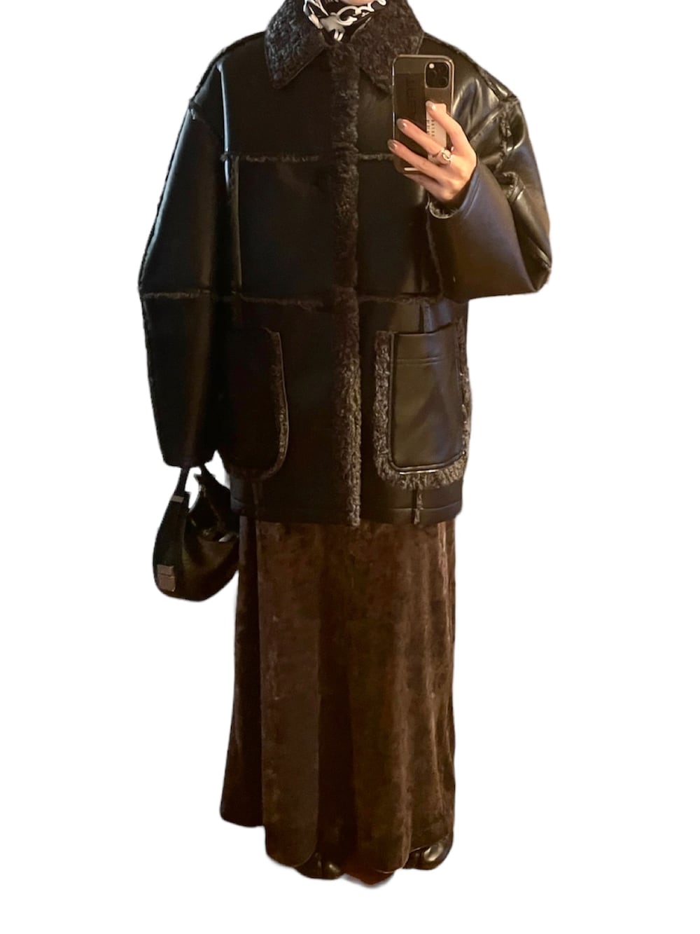 ブラック系のベスト、グレー系のスカート、ブラック系のブーツを着用したレディースの秋コーディネートの2枚目の写真