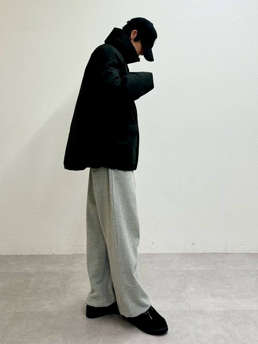 ブラック系のダウンジャケット/コート、グレー系のスウェットパンツ、ブラック系のモカシン/デッキシューズを着用したメンズの冬コーディネートの4枚目の写真