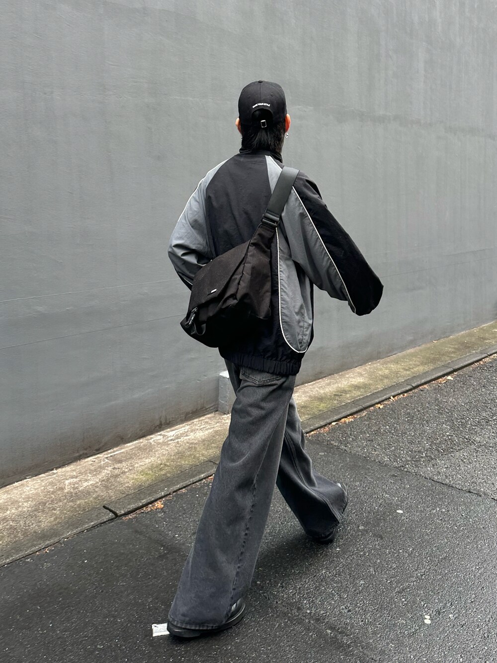 ブラック系のナイロンジャケット、ブラック系のデニムパンツ、ブラック系のショルダーバッグを着用したメンズの冬コーディネートの3枚目の写真
