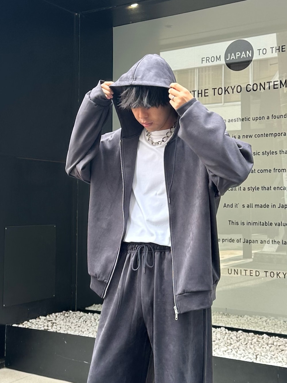 グレー系のパーカー、グレー系のスウェットパンツを着用したメンズの夏コーディネートの3枚目の写真