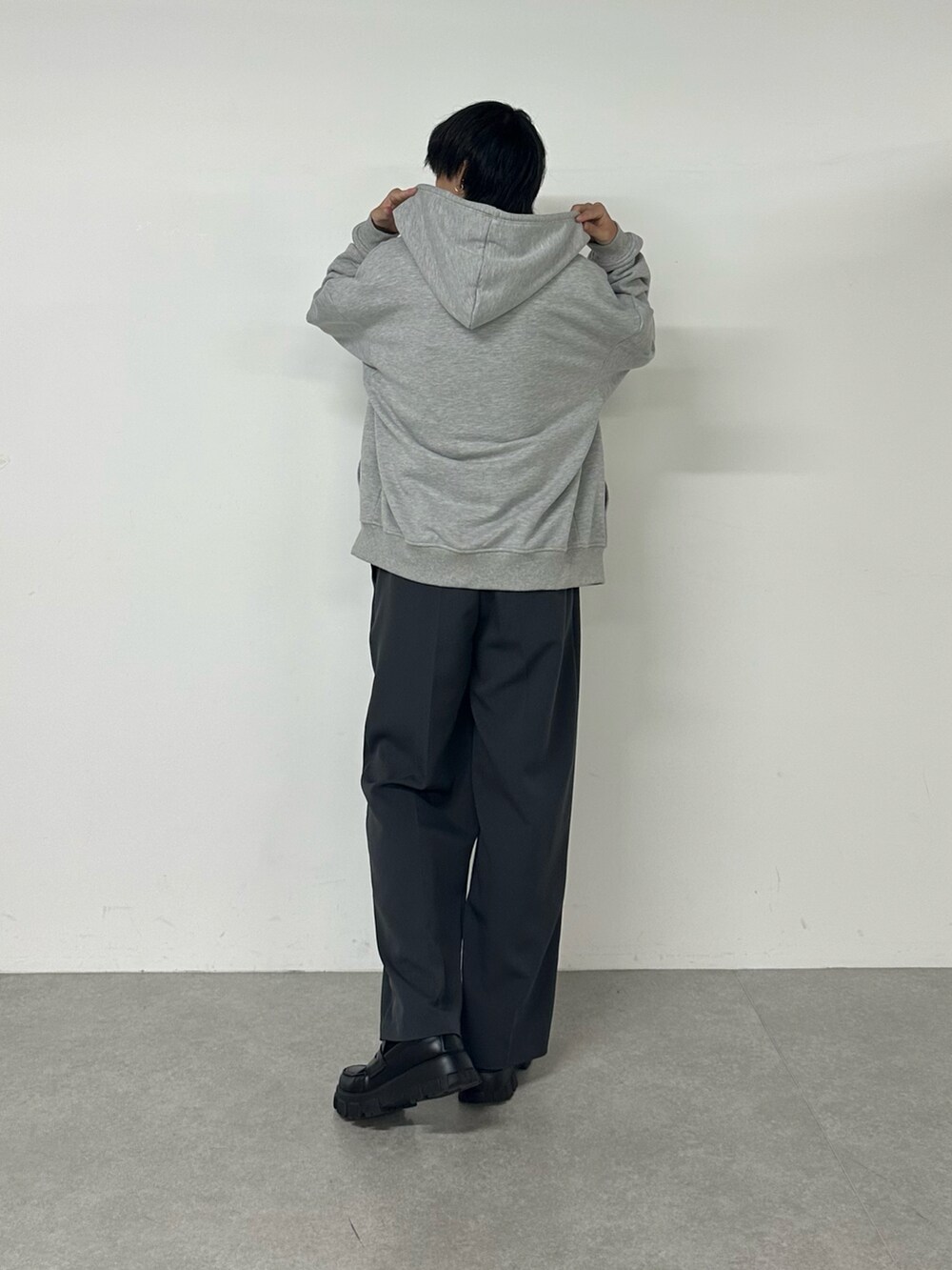 グレー系のパーカー、グレー系のスラックスを着用したメンズの秋コーディネートの3枚目の写真