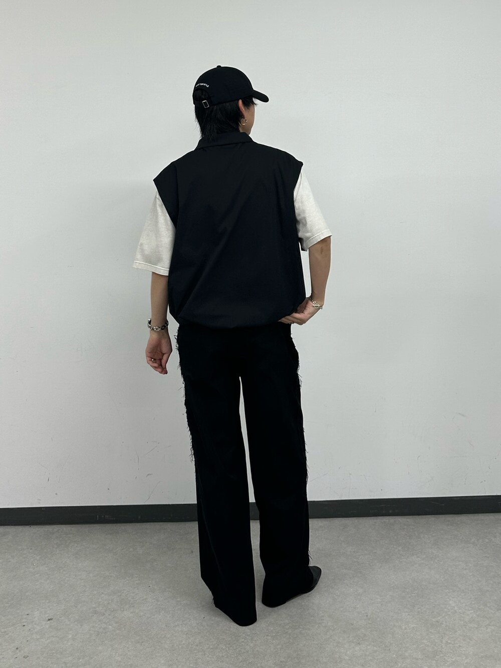 ブラック系のベスト、ホワイト系のTシャツ/カットソー、ブルー系のキャップを着用したメンズの夏コーディネートの3枚目の写真