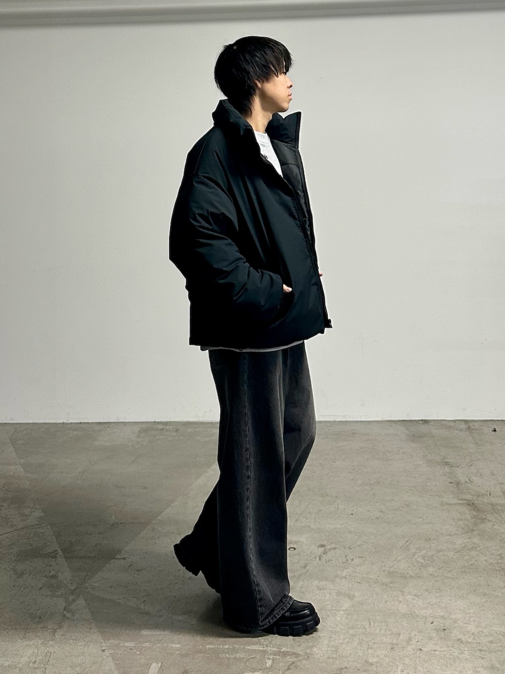 ブラック系のデニムパンツ、ブラック系のダウンジャケット/コートを着用したメンズの秋コーディネートの4枚目の写真