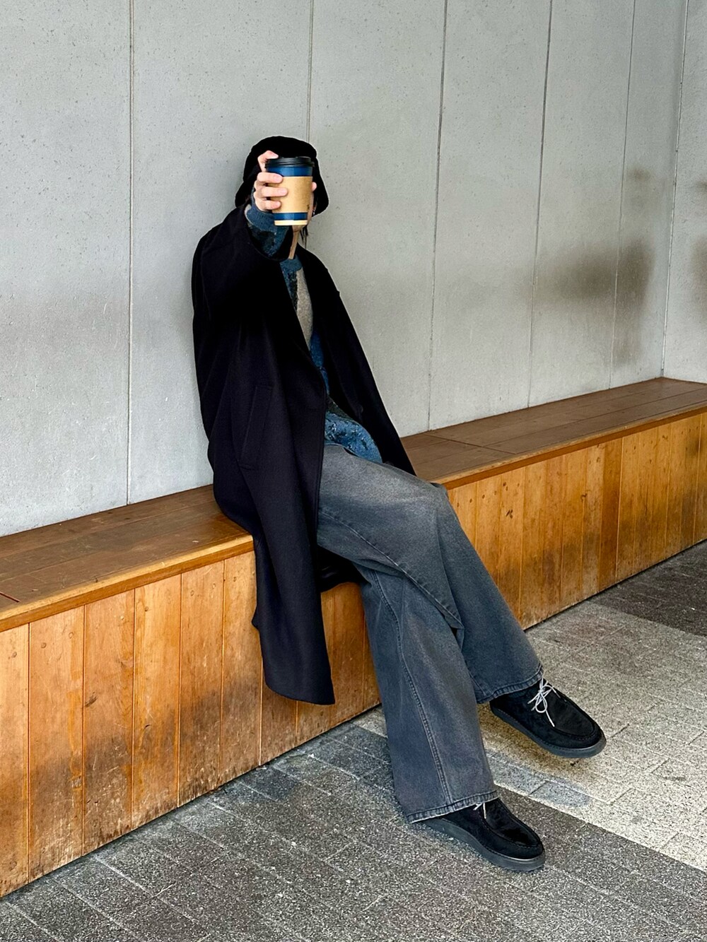 ブラック系のその他アウター、ブラック系のデニムパンツ、ブルー系のニット/セーターを着用したメンズの冬コーディネートの3枚目の写真