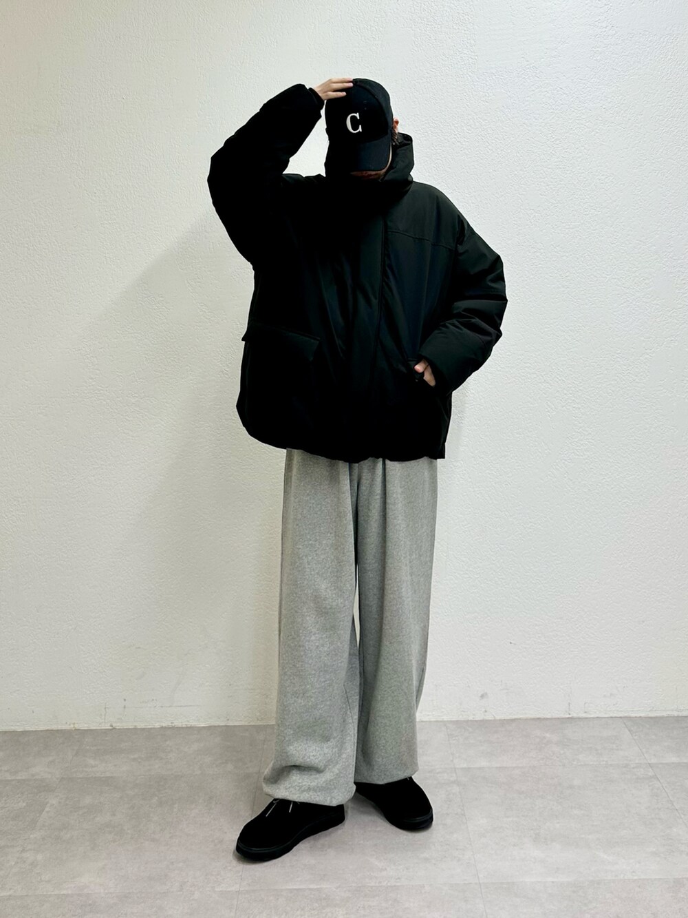 ブラック系のダウンジャケット/コート、グレー系のスウェットパンツ、ブラック系のモカシン/デッキシューズを着用したメンズの冬コーディネートの2枚目の写真