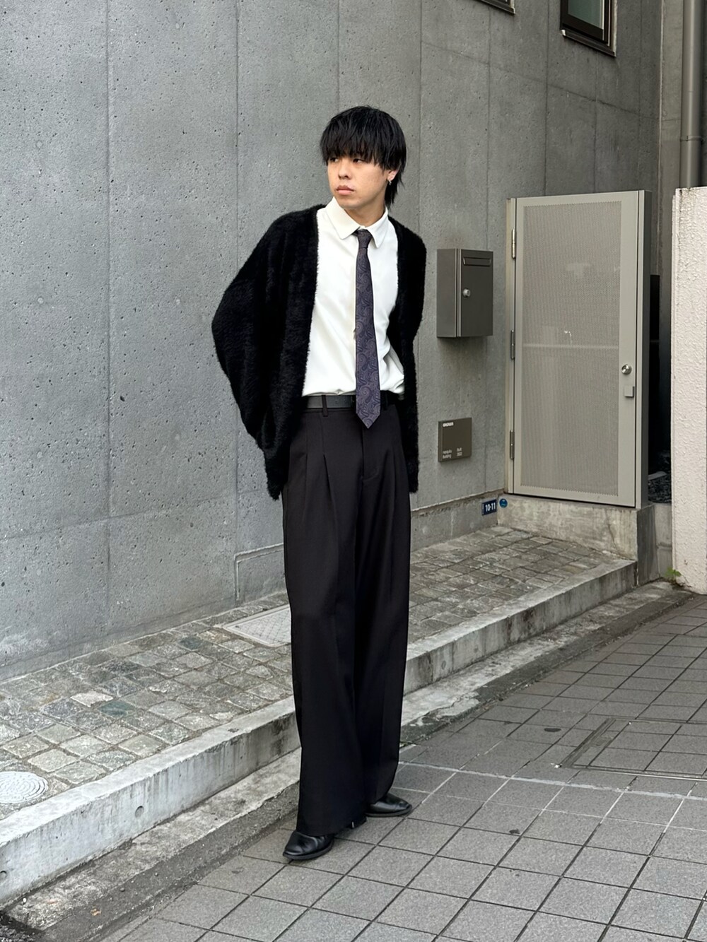 ブラック系のカーディガン/ボレロ、ブラック系のスラックスを着用したメンズの秋コーディネートの5枚目の写真