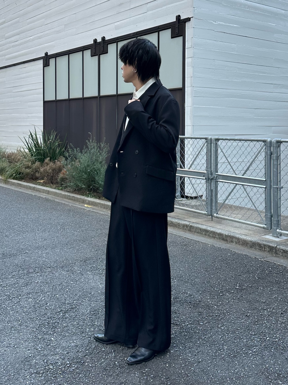 ブラック系のテーラードジャケット、ブラック系のスラックス、ブラック系のベルトを着用したメンズの冬コーディネートの2枚目の写真