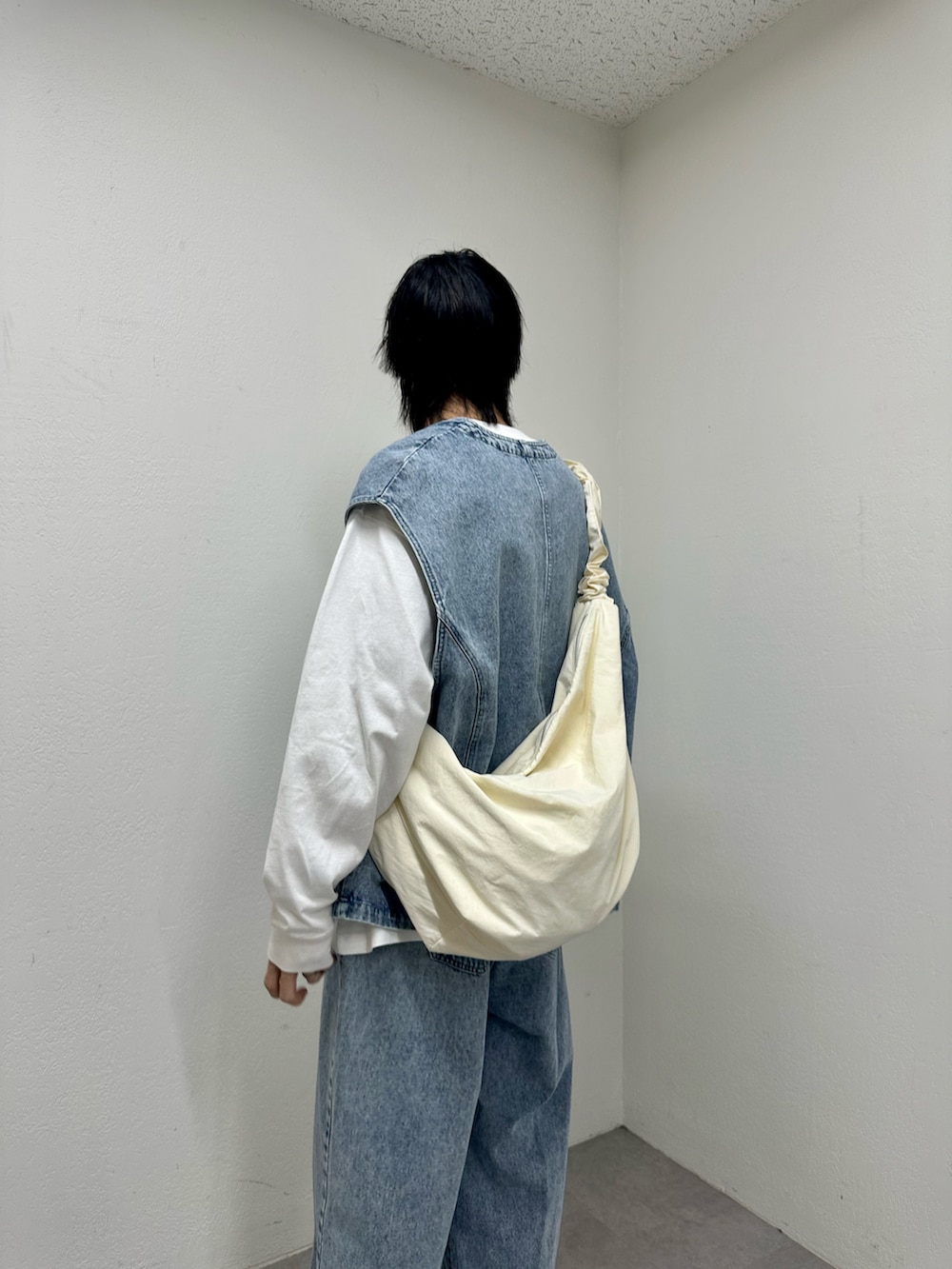 ブルー系のベスト、ブルー系のデニムパンツ、ホワイト系のTシャツ/カットソーを着用したメンズの春コーディネートの4枚目の写真