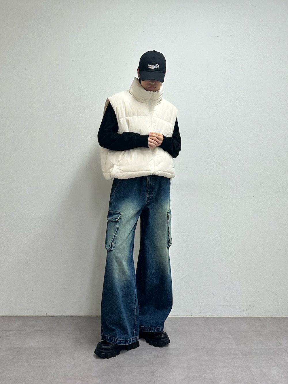 ホワイト系のダウンベスト、ブルー系のデニムパンツ、ブルー系のキャップを着用したメンズの夏コーディネートの5枚目の写真