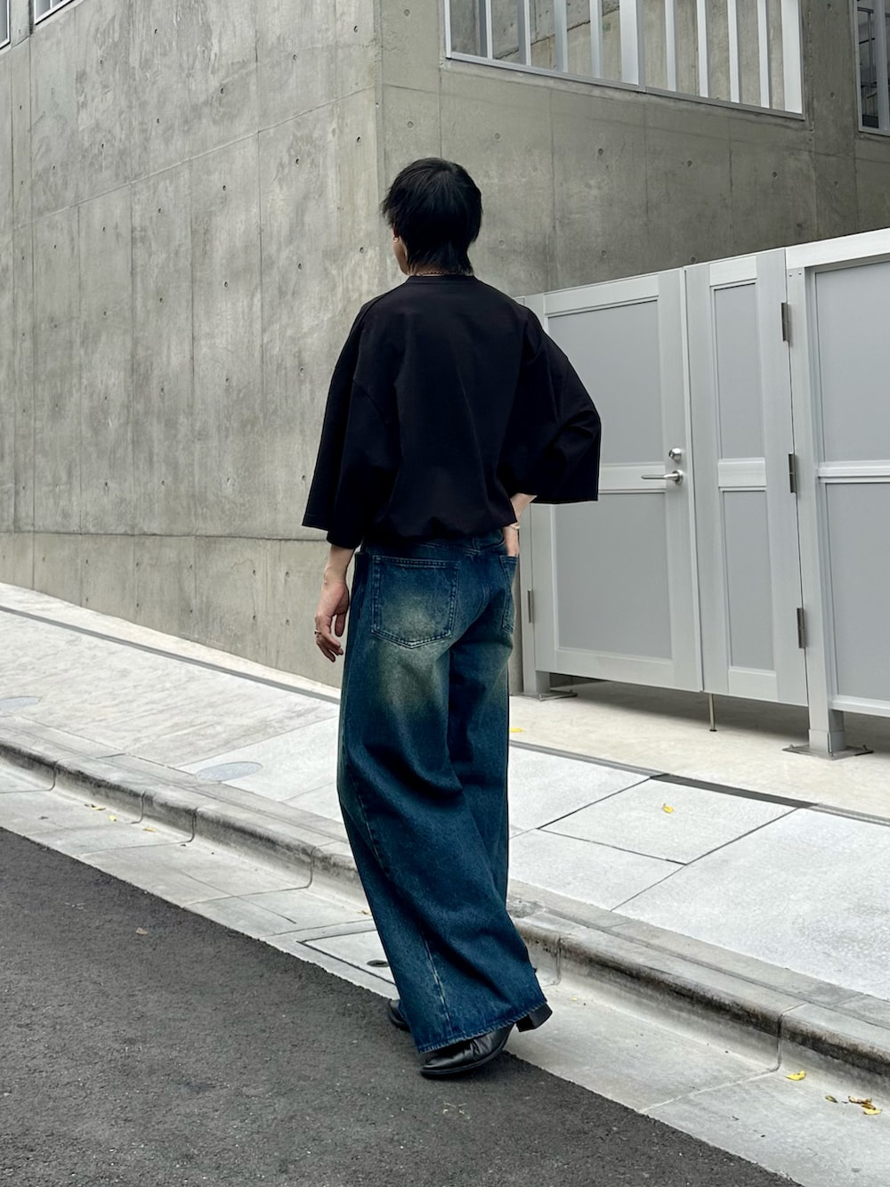 ブラック系のTシャツ/カットソー、ブルー系のデニムパンツを着用したメンズの夏コーディネートの2枚目の写真