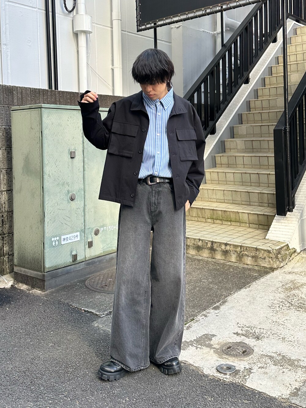 ブラック系のその他アウター、ブラック系のデニムパンツ、ブラック系のベルトを着用したメンズの冬コーディネートの5枚目の写真