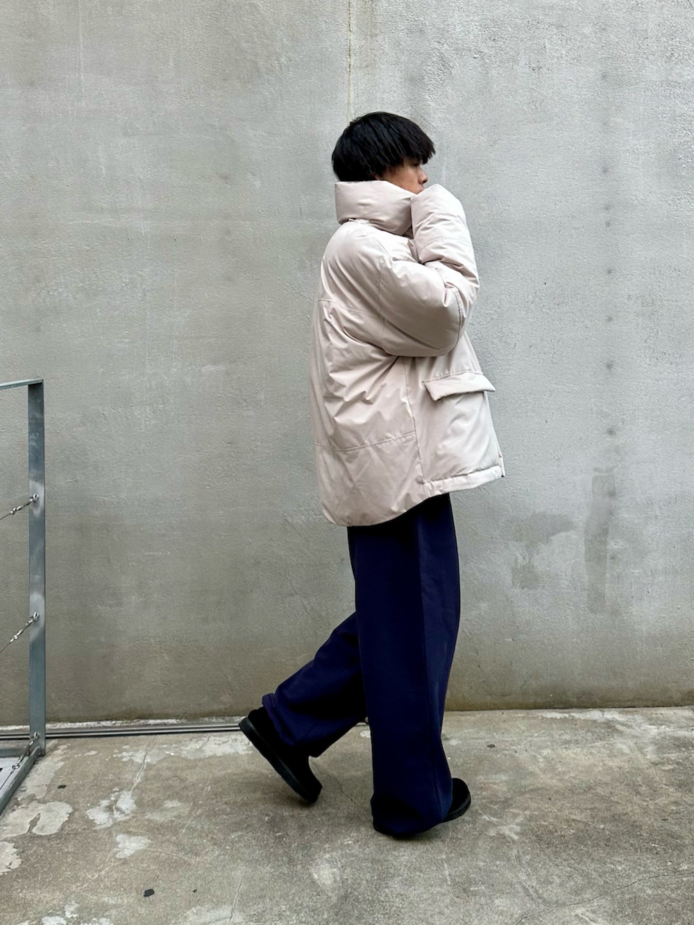 グレー系のダウンジャケット/コート、ブルー系のスウェットパンツ、ブラック系のモカシン/デッキシューズを着用したメンズの秋コーディネートの2枚目の写真