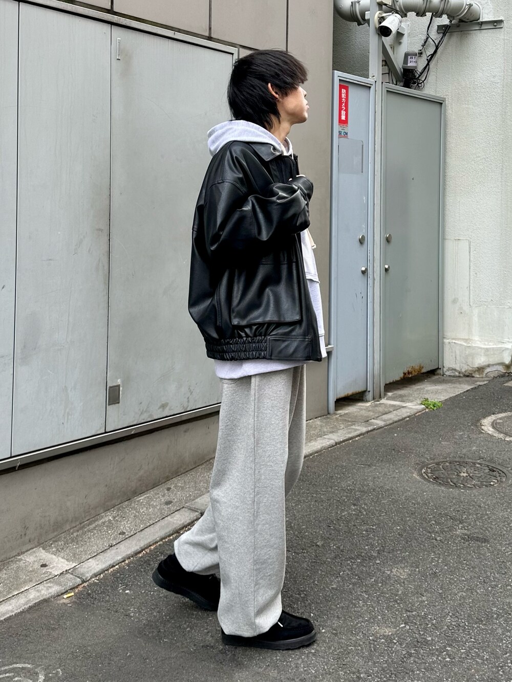 ブラック系のブルゾン、グレー系のパーカー、グレー系のスウェットパンツを着用したメンズの冬コーディネートの3枚目の写真