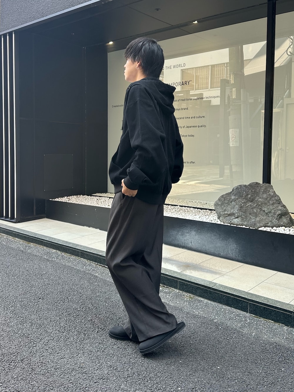 ブラック系のブルゾン、グレー系のスラックス、ブラック系のサンダルを着用したメンズの秋コーディネートの2枚目の写真