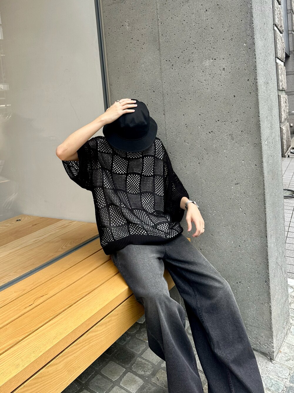 ブラック系のニット/セーター、ブラック系のデニムパンツ、ホワイト系のタンクトップを着用したメンズの夏コーディネートの2枚目の写真