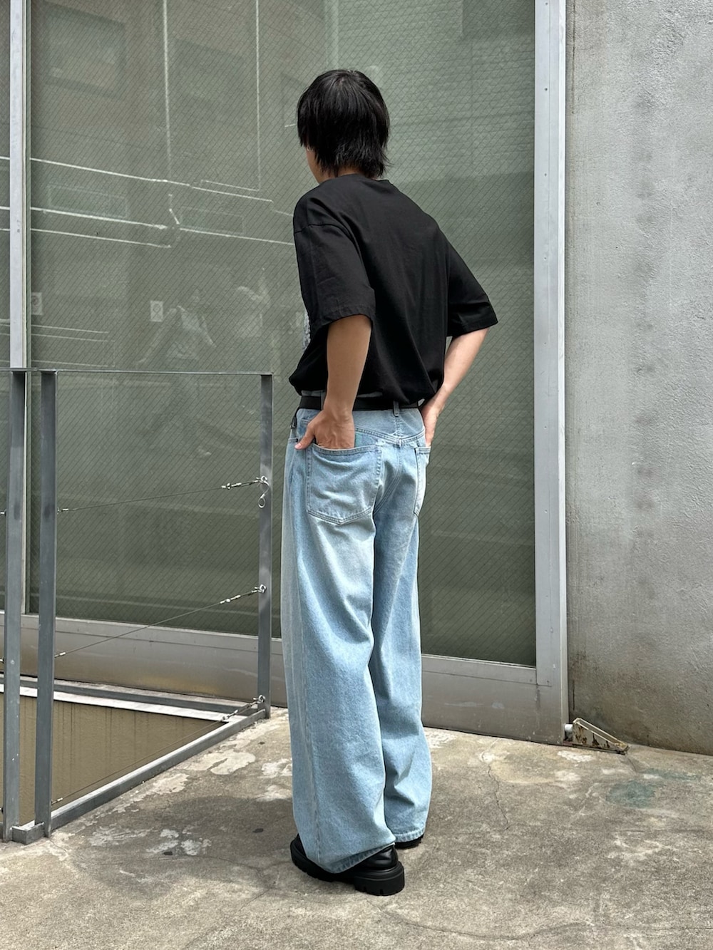 ホワイト系のTシャツ/カットソー、ブルー系のデニムパンツ、ブラック系のベルトを着用したメンズの春コーディネートの2枚目の写真