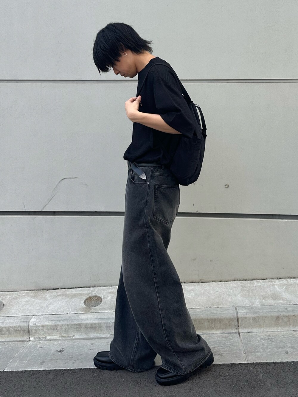 ブラック系のTシャツ/カットソー、ブラック系のバックパック/リュック、ブラック系のデニムパンツを着用したメンズの春コーディネートの4枚目の写真