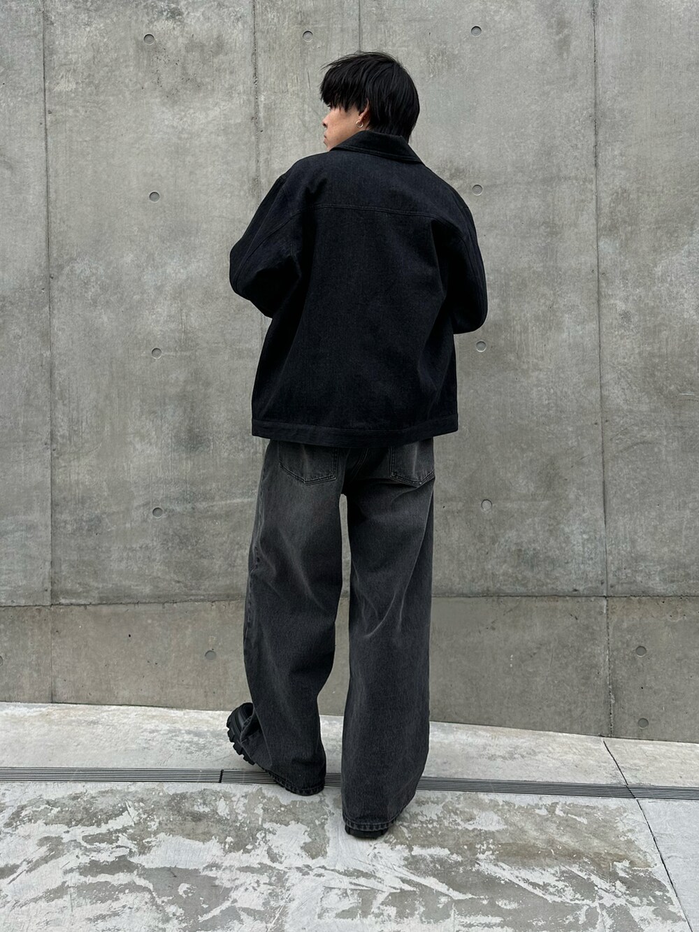 ブラック系のデニムジャケット、グレー系のTシャツ/カットソー、ブラック系のデニムパンツを着用したメンズの冬コーディネートの3枚目の写真