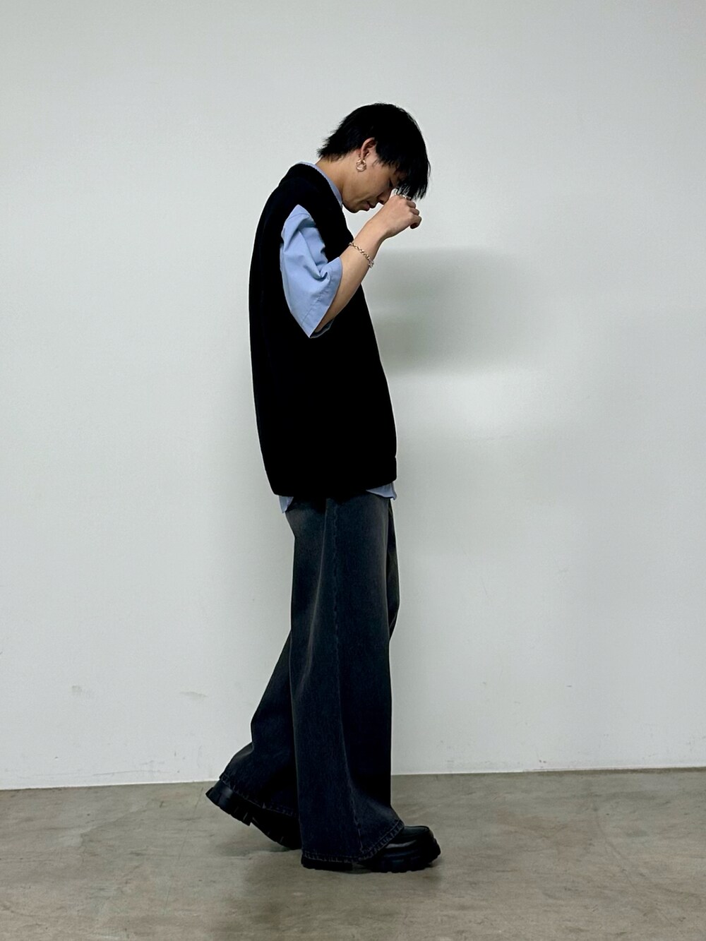 ブラック系のベスト、ブルー系のシャツ/ブラウス、ブラック系のデニムパンツを着用したメンズの春コーディネートの2枚目の写真