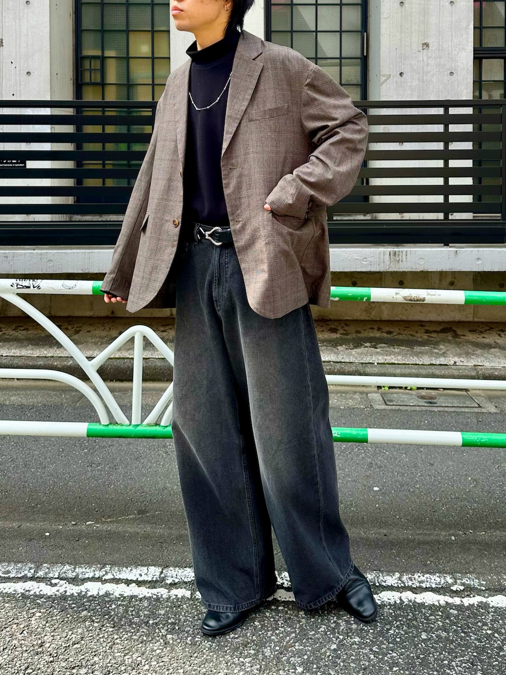 ブラウン系のテーラードジャケット、ブラック系のデニムパンツ、ブラック系のベルトを着用したメンズの秋コーディネートの3枚目の写真