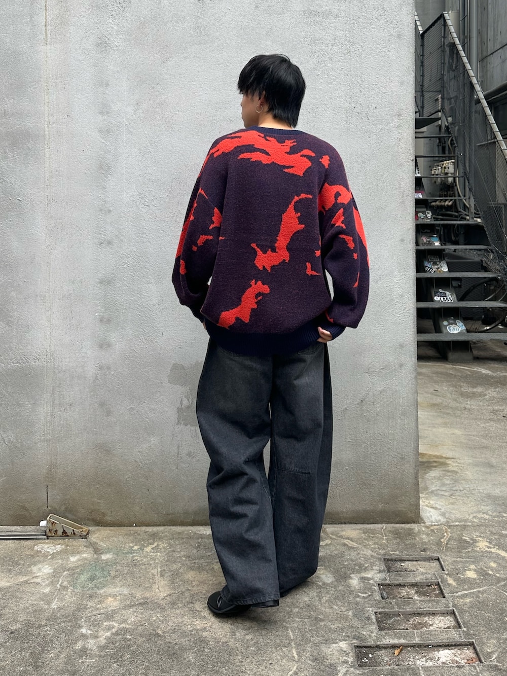 ブルー系のニット/セーター、ブラック系のデニムパンツ、ブラック系のブーツを着用したメンズの秋コーディネートの3枚目の写真