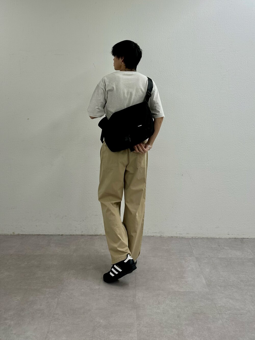 ベージュ系のその他パンツ、ホワイト系のTシャツ/カットソー、ブラック系のショルダーバッグを着用したメンズの春コーディネートの2枚目の写真