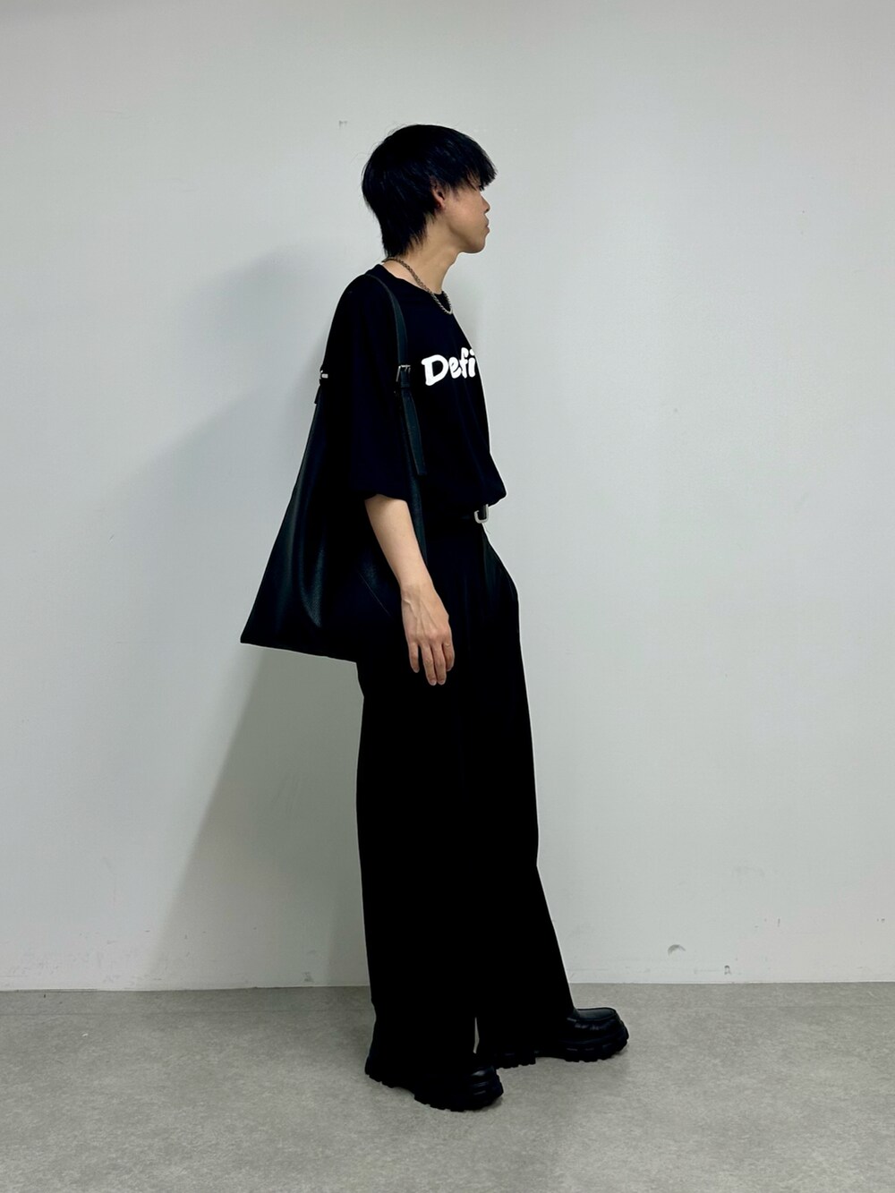 ブラック系のTシャツ/カットソー、ブラック系のスラックス、ブラック系のトートバッグを着用したメンズの夏コーディネートの2枚目の写真