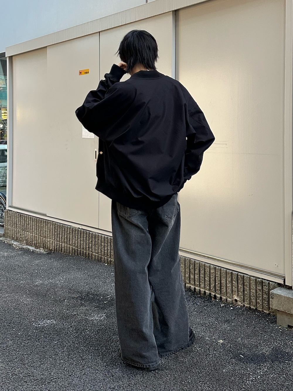 ブラック系のMA-1、ブラック系のデニムパンツ、ブラック系のTシャツ/カットソーを着用したメンズの冬コーディネートの3枚目の写真