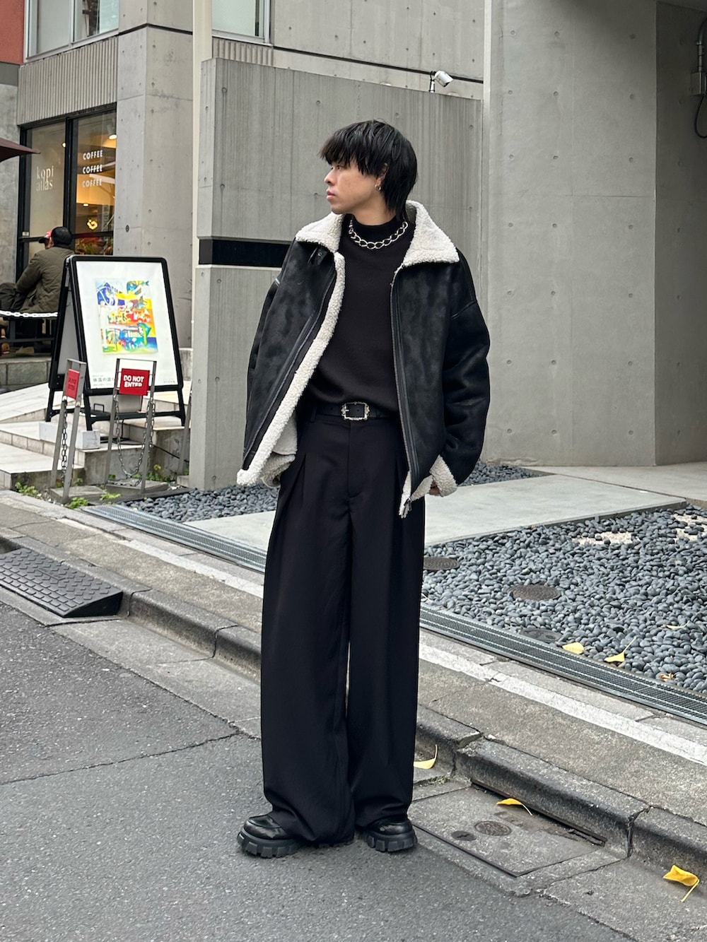 ブラック系のムートンコート、ブラック系のニット/セーターを着用したメンズの冬コーディネートの4枚目の写真