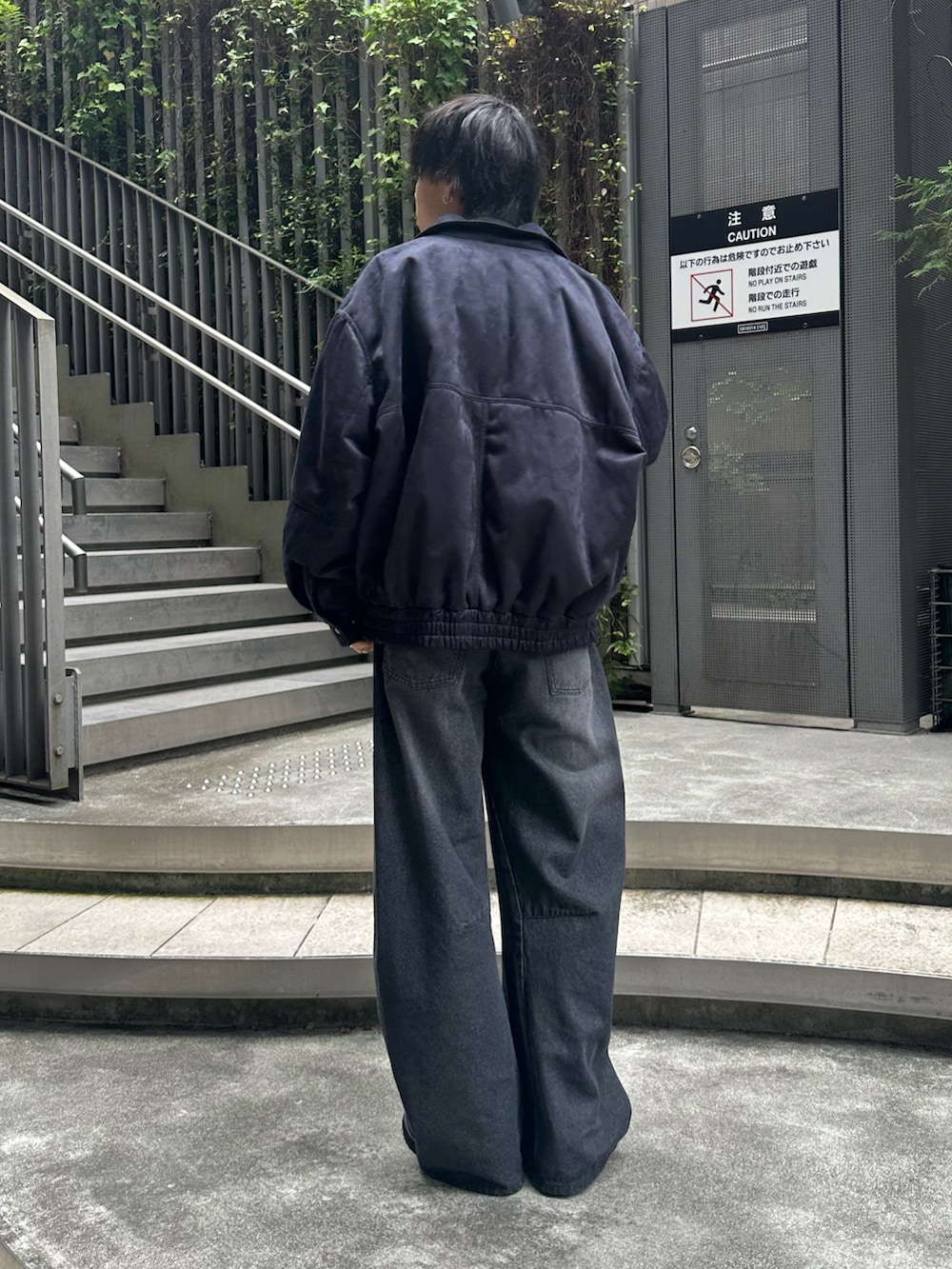 ブラック系のブルゾン、ブラック系のデニムパンツ、ブラック系のドレスシューズを着用したメンズの秋コーディネートの3枚目の写真