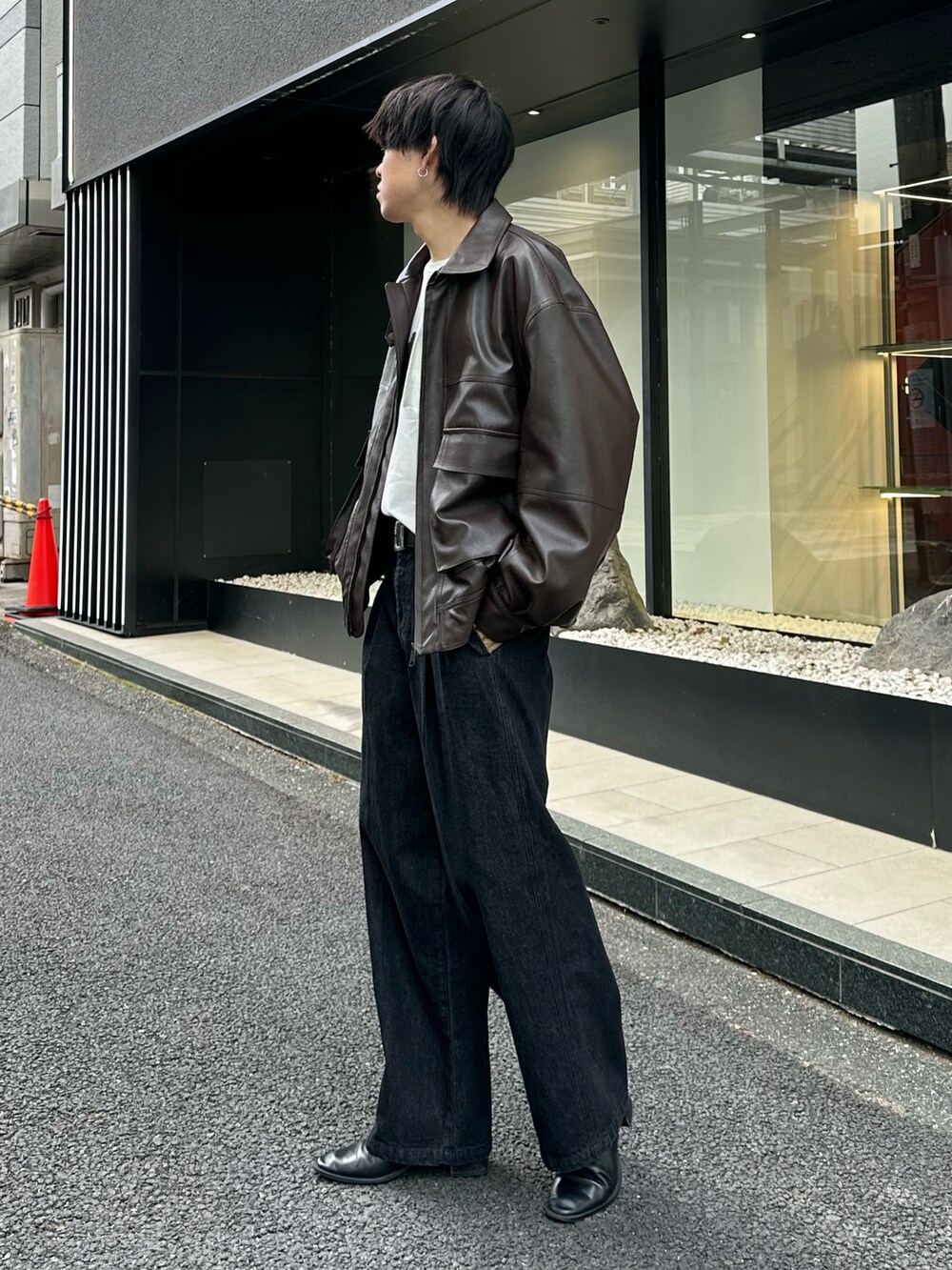 ブラック系のブルゾン、ホワイト系のTシャツ/カットソー、ブラック系のデニムパンツを着用したメンズの冬コーディネートの2枚目の写真