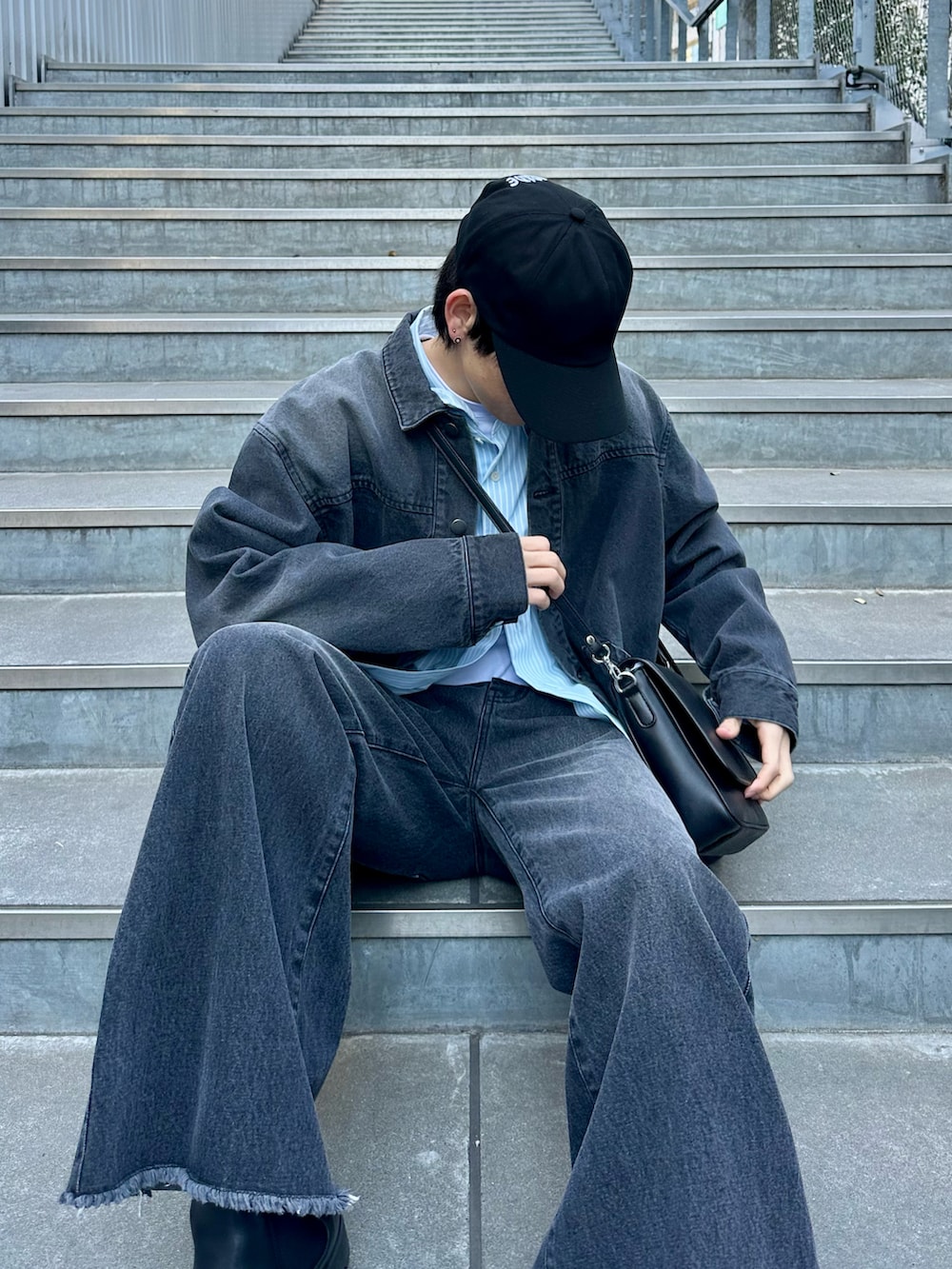 ブラック系のデニムジャケット、ブルー系のシャツ/ブラウス、ブラック系のデニムパンツを着用したメンズの冬コーディネートの5枚目の写真