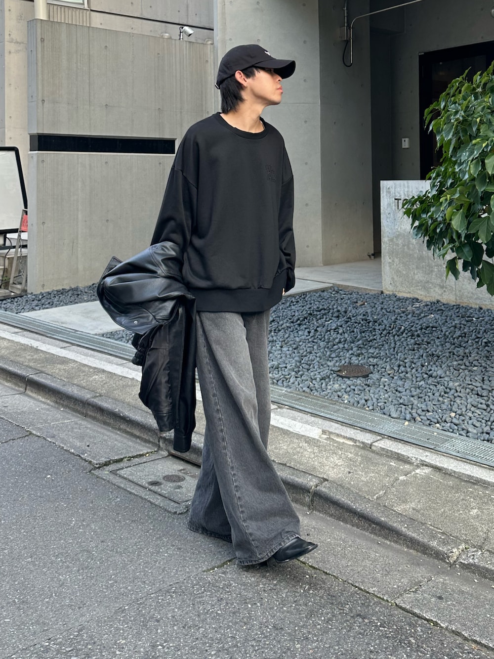 ブラック系のTシャツ/カットソー、ブラック系のデニムパンツ、ブラック系のブルゾンを着用したメンズの秋コーディネートの4枚目の写真